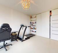 A study with a desk, chair, treadmill, and shelf in a 4-room apartment.