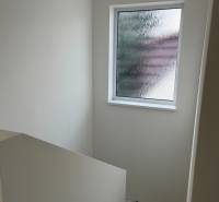 A staircase in a family house with a window with frosted glass.