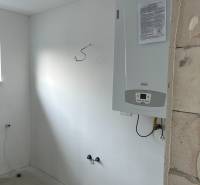 The interior of a family house with a boiler mounted on the wall.