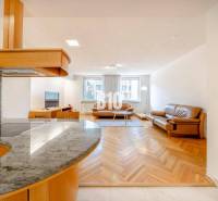 Living room in a three-room apartment with a wooden decor floor and leather furniture.