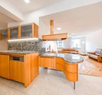 Spacious kitchen with wooden decor and bright living room in a 3-room apartment.