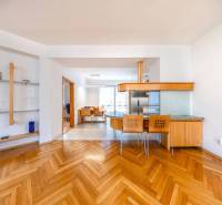 Interior of a 3-room apartment with wood-patterned flooring, a dining area, and an open kitchen.