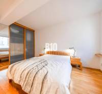 Bedroom in a 3-room apartment with a bed, wardrobe, nightstands, and a floor with a wooden decor.