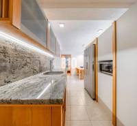 A kitchen in a 3-room apartment with a marble countertop and built-in appliances.