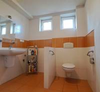 A bathroom in a family house with orange and white tiles and sanitary ware.