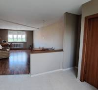 Interior of a family house with a living room, sofa, and computer by the window.