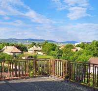 The view from the family house in Hronské Kosihy to greenery, houses, and hills.