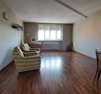Living room in a family house with wooden flooring, a sofa, and a table.
