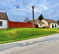 Family houses in Budmerice with grassy gardens and wooden fences.