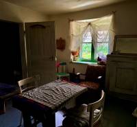 The interior of a family house with antique furniture, floral patterns, and a rustic atmosphere.