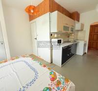 A kitchen in a 2-room apartment with rustic wooden decor and a kitchen unit.