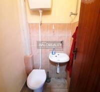 Small bathroom with a toilet, sink, and tiles in offices.