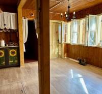 The interior with a wood-patterned floor is dominated by rustic furniture and bright lighting.