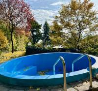 A swimming pool surrounded by autumn trees on a residential property in Bratislava, Karlova Ves on Hany Meličkovej.