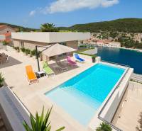 Villa in the town of Bol with a pool, terrace, colorful loungers, and a sea view.