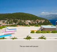 A villa in the town of Bol with a terrace, sunbeds, and a jacuzzi overlooking the surrounding houses and the sea.