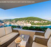 A balcony in a villa in the town of Bol with a view of the bay and greenery.