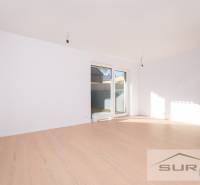 A bright living room with wood-patterned flooring and a large window in a two-room apartment.