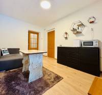 Living room in a cabin with a sofa, table, and wooden decor flooring.