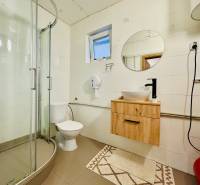 A bathroom in a cabin with a modern shower and wooden decor on the sink cabinet.