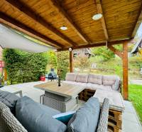Garden seating at the Cottage on Trnkova Street in Bžany with wooden elements and greenery.
