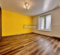 Interior of a 3-room apartment with a yellow wall and a floor with a wooden decor.