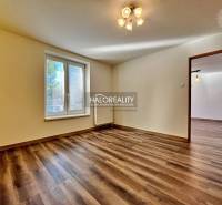 A room in a 3-room apartment with a wooden decor floor and a large window.