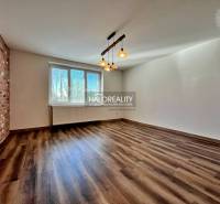 A room in a 3-room apartment with a wooden decor floor and a brick wall cladding.
