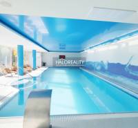 A pool with blue ceilings and loungers in indoor dining areas.