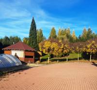 A view of the garden of a family house in Necpaly with a paved area and a swimming pool.