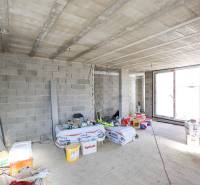 The entrance hall under construction in a family house with concrete walls and building materials.