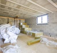 Basement space in a family house with stored building materials and a bag of fabric.