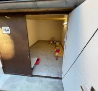 Interior of a garage with open doors, wooden decor flooring, storage space.