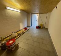 Garages with tools and lighting, floor with wooden decor, open doors to daylight.