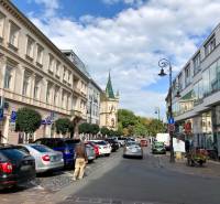 Mlynská Street in the Staré Mesto district, Košice; cars and pedestrians in front of buildings.