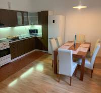 A kitchen with a dining table in a 2-room apartment, floor with wooden decor.