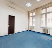 Offices with blue carpet, white walls, and large windows.