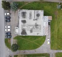 A top view of commercial premises in Rimavská Sobota, surrounded by greenery and parked cars.