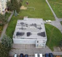 Commercial premises in Rimavská Sobota with a flat roof, surrounded by greenery and apartment buildings.