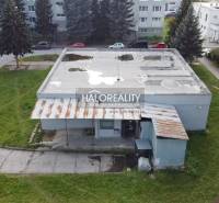 View of commercial premises in Rimavská Sobota with an adjacent park and a concrete roof.