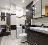 Bathroom in a 2-room apartment with a shower, washing machine, and sink.