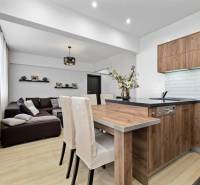 Living room and kitchen with wood-patterned flooring in a two-room apartment.