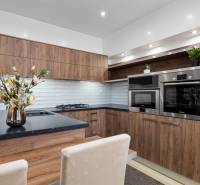 Kitchen in a 2-room apartment, wooden decor, white tiles, built-in appliances.