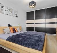 Bedroom in a 2-room apartment with a bed, wardrobe, and decorations, floor with wooden decor.