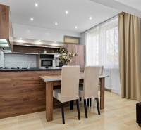 Kitchen in a 2-room apartment with a dining area and a wooden-patterned floor.