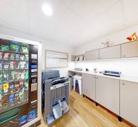 Offices with a vending machine, printer, and cabinets, floor with wood decor.