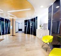 Reception of offices with wood-decor flooring and greenery on the wall.