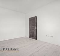Interior of a 2-room apartment with white walls and a wooden decor floor.