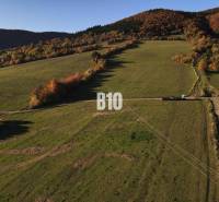 A landscape with residential plots in Petrovice, surrounded by hills and forests in autumn.
