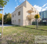 The exterior of the apartment building on Železničná Street in Vrakuňa with an adjacent garden.